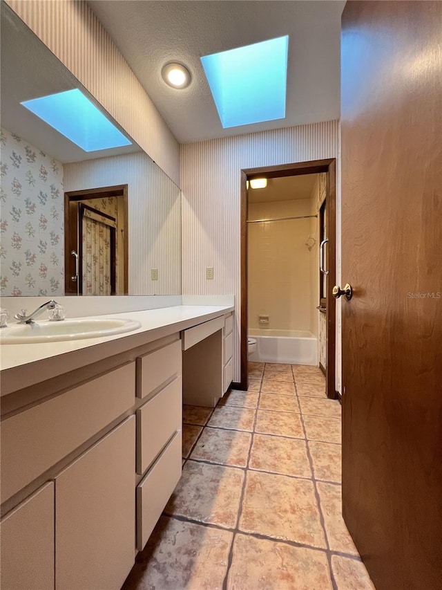 full bathroom featuring vanity, shower / washtub combination, a textured ceiling, and a skylight