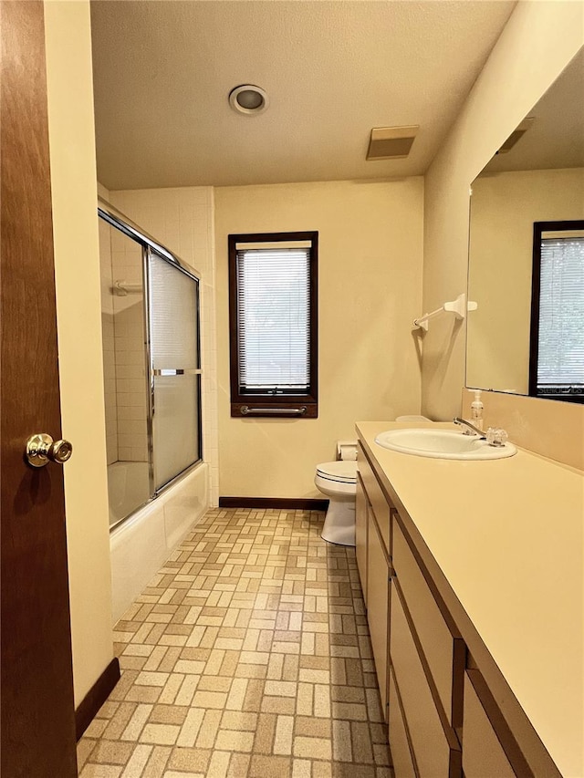 full bathroom featuring vanity, toilet, and combined bath / shower with glass door