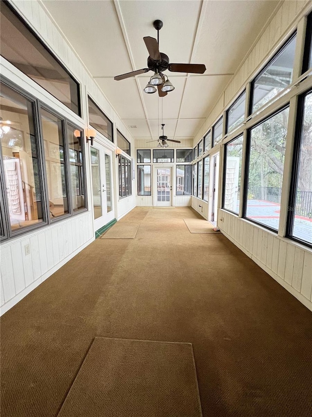 unfurnished sunroom featuring ceiling fan