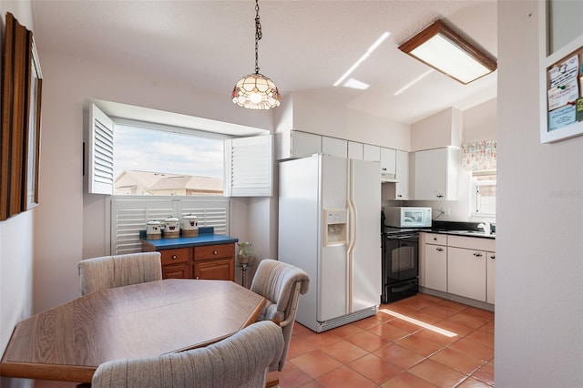 kitchen with light tile patterned flooring, pendant lighting, sink, white cabinets, and white appliances