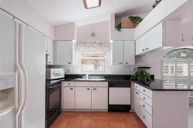 kitchen featuring light tile patterned flooring, vaulted ceiling, sink, white cabinets, and white appliances