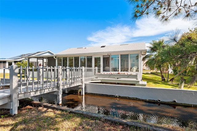 back of property featuring a wooden deck and a sunroom