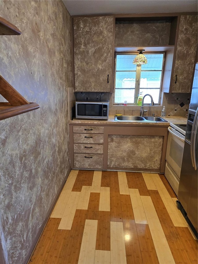 kitchen featuring stainless steel appliances, sink, and light hardwood / wood-style floors