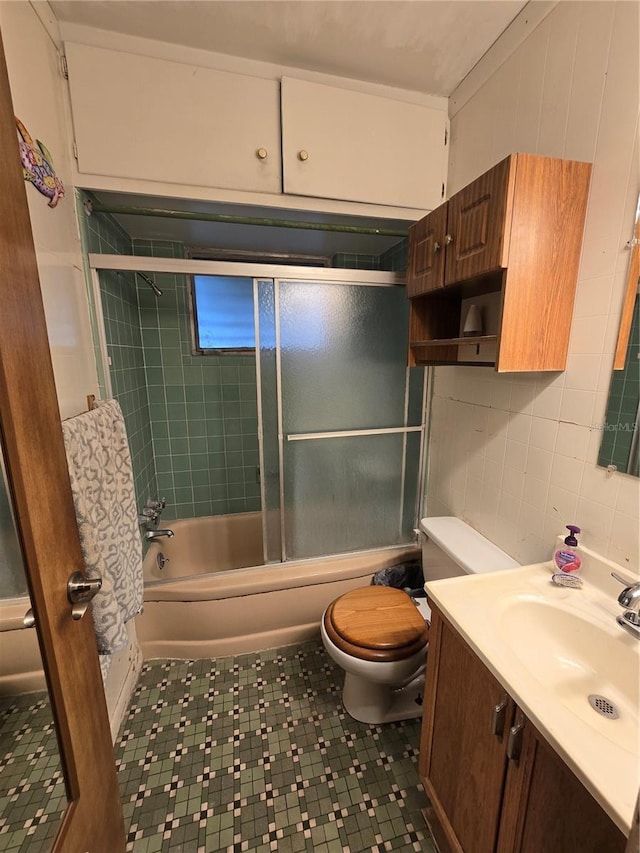 full bathroom with vanity, combined bath / shower with glass door, and toilet