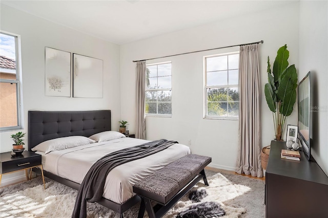 bedroom featuring multiple windows and light wood-type flooring