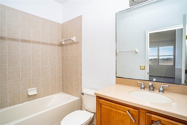 full bathroom featuring vanity, tiled shower / bath, and toilet