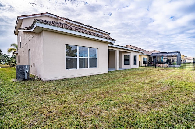 rear view of house with a yard and central AC unit