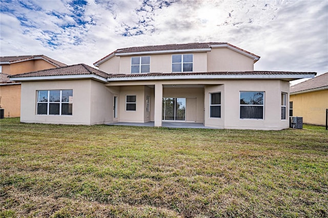 back of property with a yard, central AC unit, and a patio area