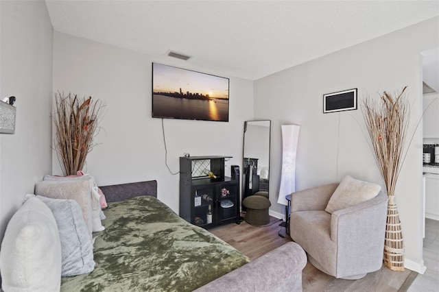 bedroom featuring light hardwood / wood-style floors and a textured ceiling