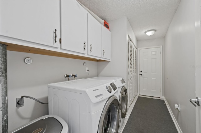 laundry area featuring cabinets, separate washer and dryer, and a textured ceiling