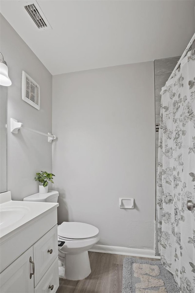 bathroom featuring vanity, hardwood / wood-style flooring, curtained shower, and toilet