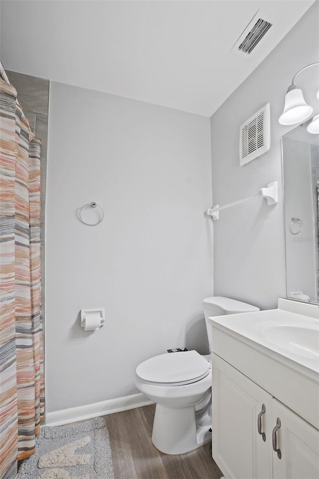 bathroom featuring vanity, wood-type flooring, and toilet