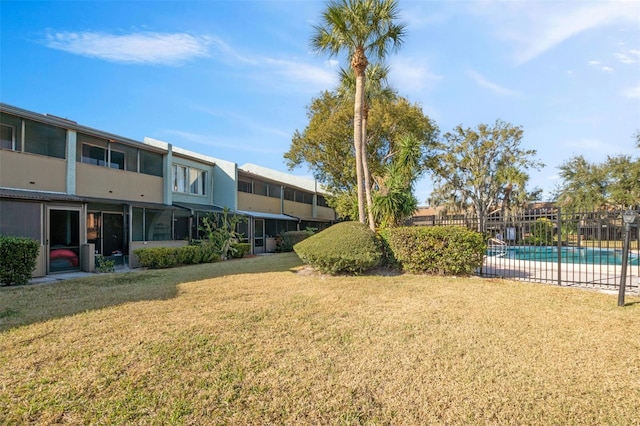 view of property's community featuring a yard and a swimming pool