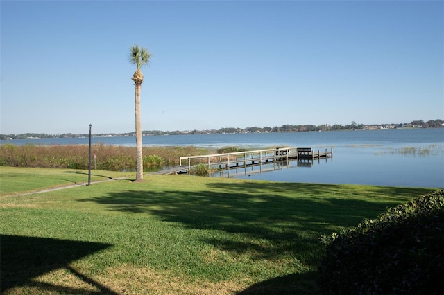 dock area featuring a water view and a lawn