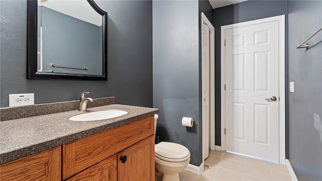 bathroom featuring vanity, tile patterned floors, and toilet