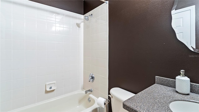 full bathroom featuring tiled shower / bath, vanity, and toilet