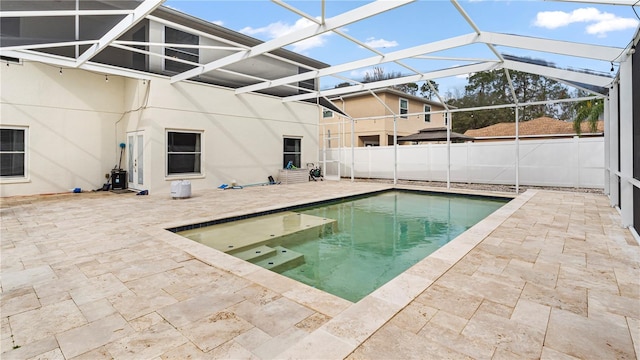 view of swimming pool featuring a patio and glass enclosure