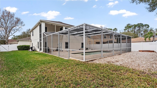 rear view of house with a fenced in pool, a patio, and a yard