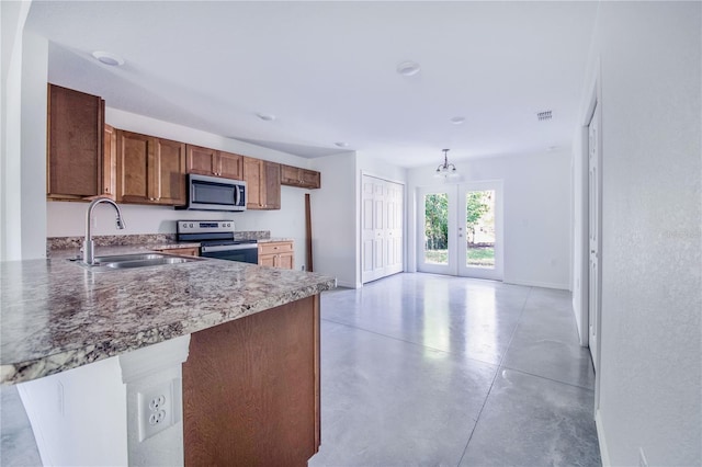 kitchen with french doors, a kitchen bar, sink, appliances with stainless steel finishes, and kitchen peninsula