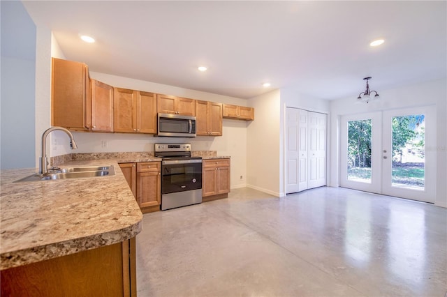 kitchen with french doors, appliances with stainless steel finishes, decorative light fixtures, and sink