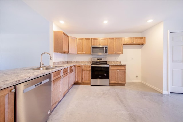 kitchen featuring stainless steel appliances, light stone countertops, sink, and light brown cabinetry