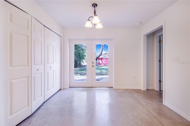 unfurnished dining area featuring french doors and a chandelier