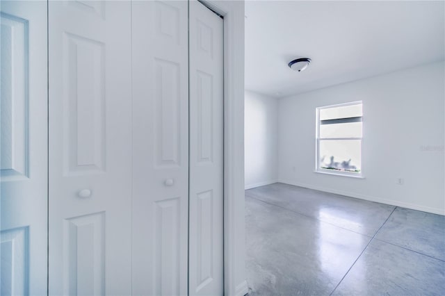 unfurnished bedroom featuring concrete floors and a closet