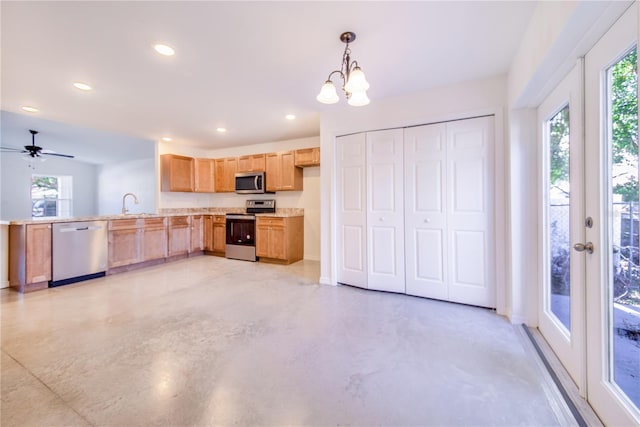 kitchen with hanging light fixtures, appliances with stainless steel finishes, plenty of natural light, and sink