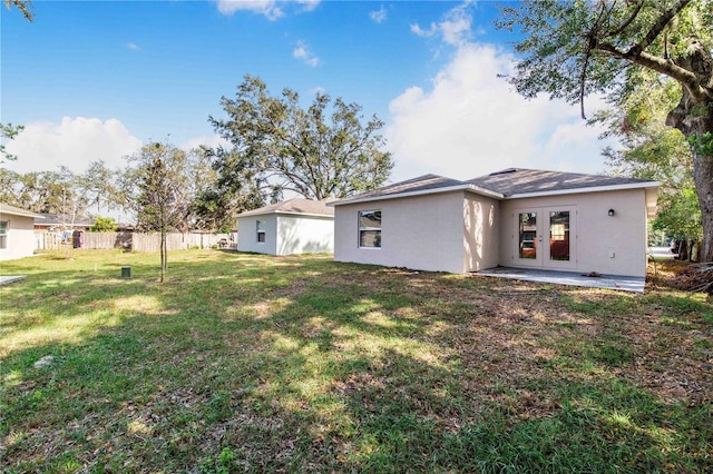 rear view of property with a lawn and french doors