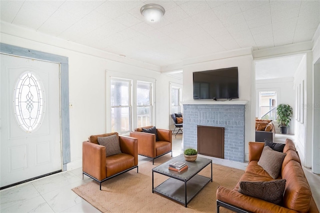 living room featuring a brick fireplace and ornamental molding