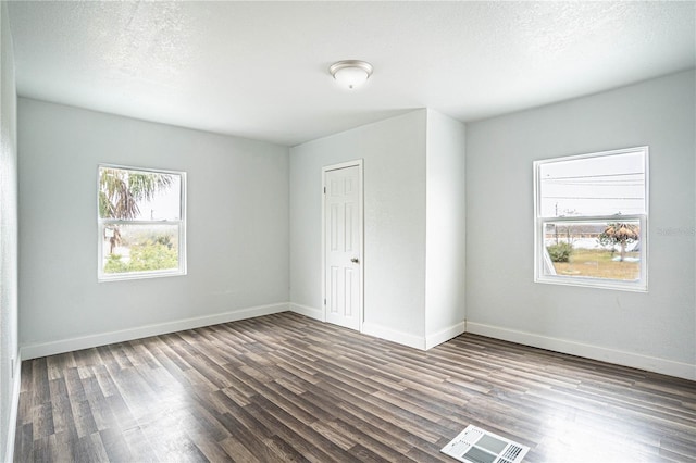 spare room with dark wood-type flooring and a textured ceiling