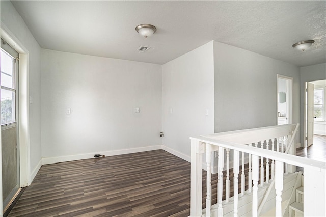 spare room with dark hardwood / wood-style flooring and a textured ceiling