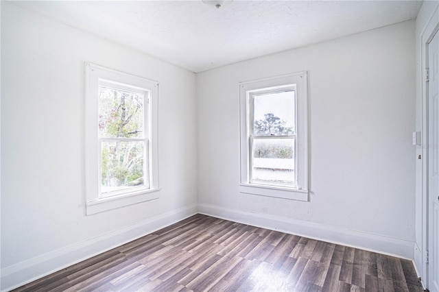 empty room with dark hardwood / wood-style flooring