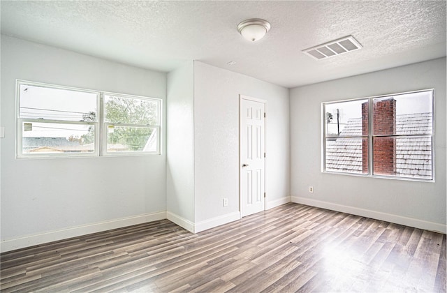 spare room featuring wood-type flooring and a textured ceiling