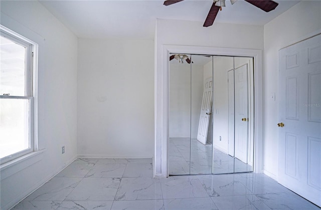 unfurnished bedroom with ceiling fan and a closet