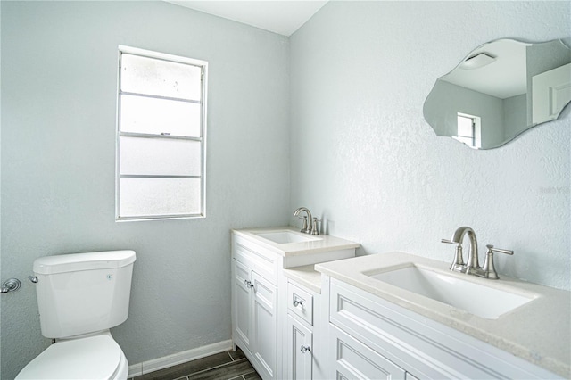 bathroom with vanity, a wealth of natural light, and toilet