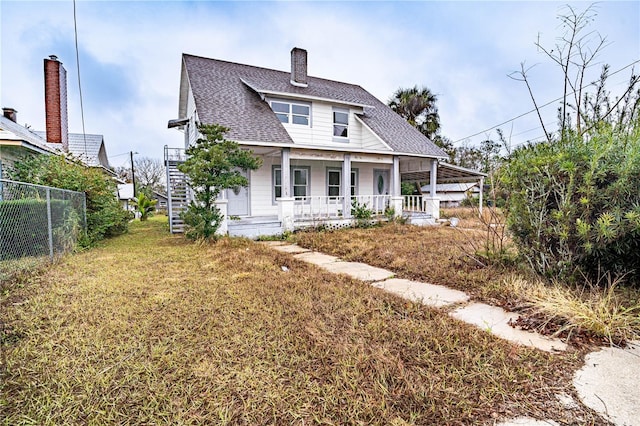 back of house featuring a yard and covered porch