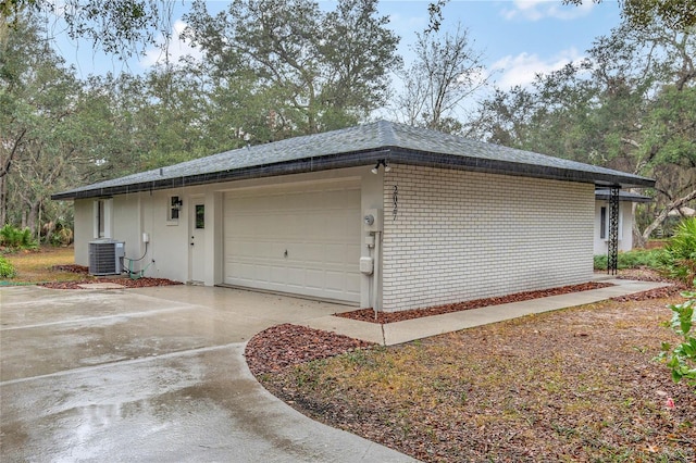 view of side of home with cooling unit and a garage