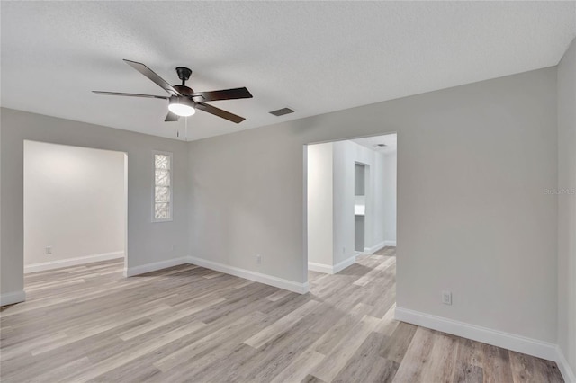 spare room with ceiling fan, light hardwood / wood-style floors, and a textured ceiling