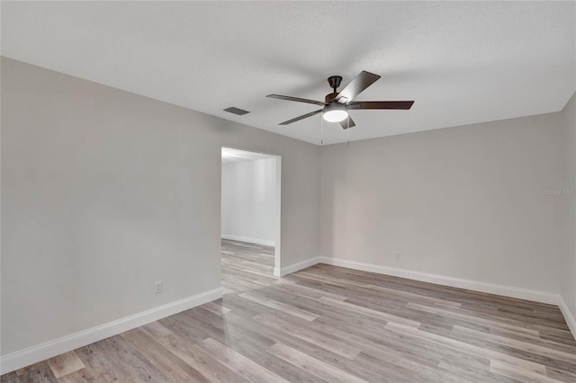 empty room featuring a textured ceiling, light hardwood / wood-style floors, and ceiling fan