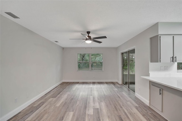 interior space with ceiling fan, light hardwood / wood-style floors, and a textured ceiling