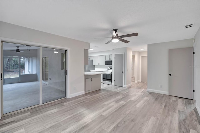 unfurnished living room featuring ceiling fan and light hardwood / wood-style flooring