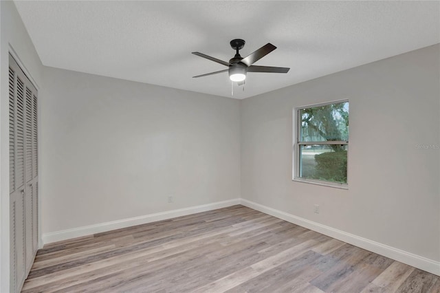 unfurnished bedroom with a textured ceiling, a closet, ceiling fan, and light wood-type flooring