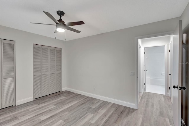 unfurnished bedroom featuring multiple closets, light hardwood / wood-style flooring, and ceiling fan