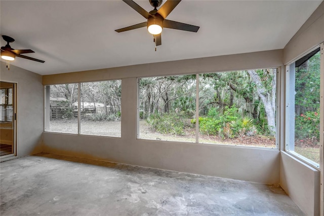 unfurnished sunroom featuring vaulted ceiling, plenty of natural light, and ceiling fan