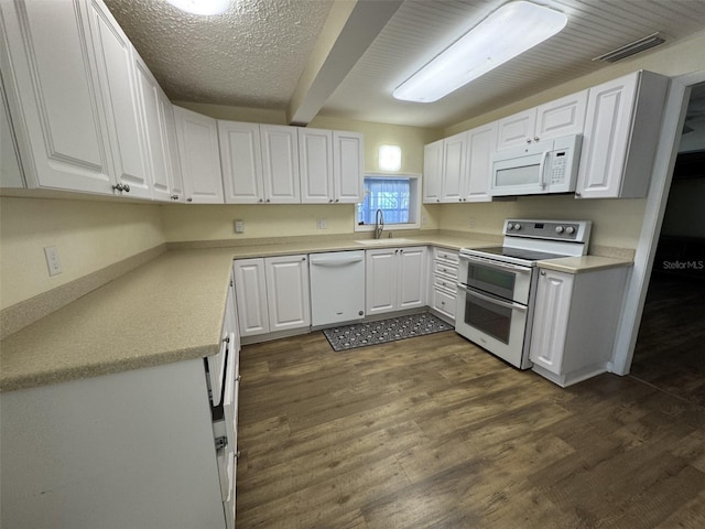 kitchen featuring sink, white appliances, white cabinetry, beam ceiling, and dark hardwood / wood-style floors