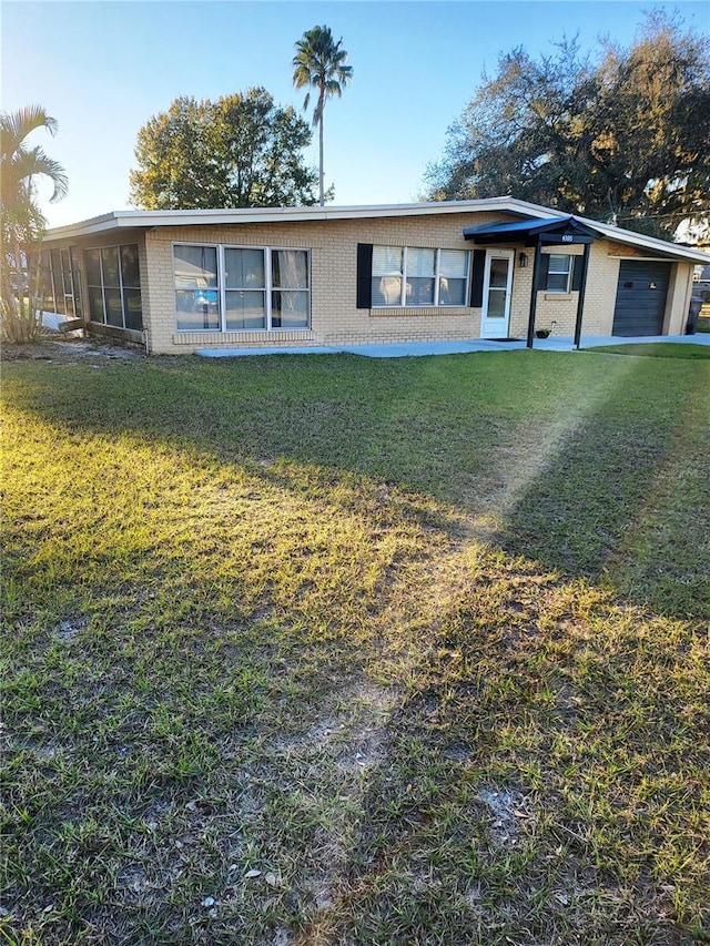 ranch-style house featuring a garage and a front lawn