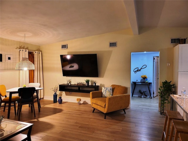 living room featuring beamed ceiling and hardwood / wood-style flooring