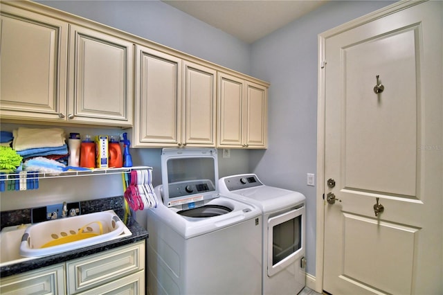 washroom featuring cabinets, separate washer and dryer, and sink