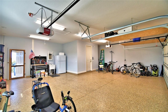 garage with white refrigerator, sink, and a garage door opener